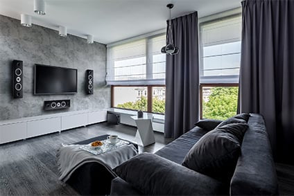 HECO on-wall speakers mounted above entertainment center in living room