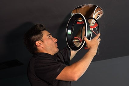 Audio Advice installer installing an in-wall speaker frame into a ceiling.