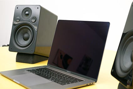 Peachtree M24 speakers on desk beside laptop