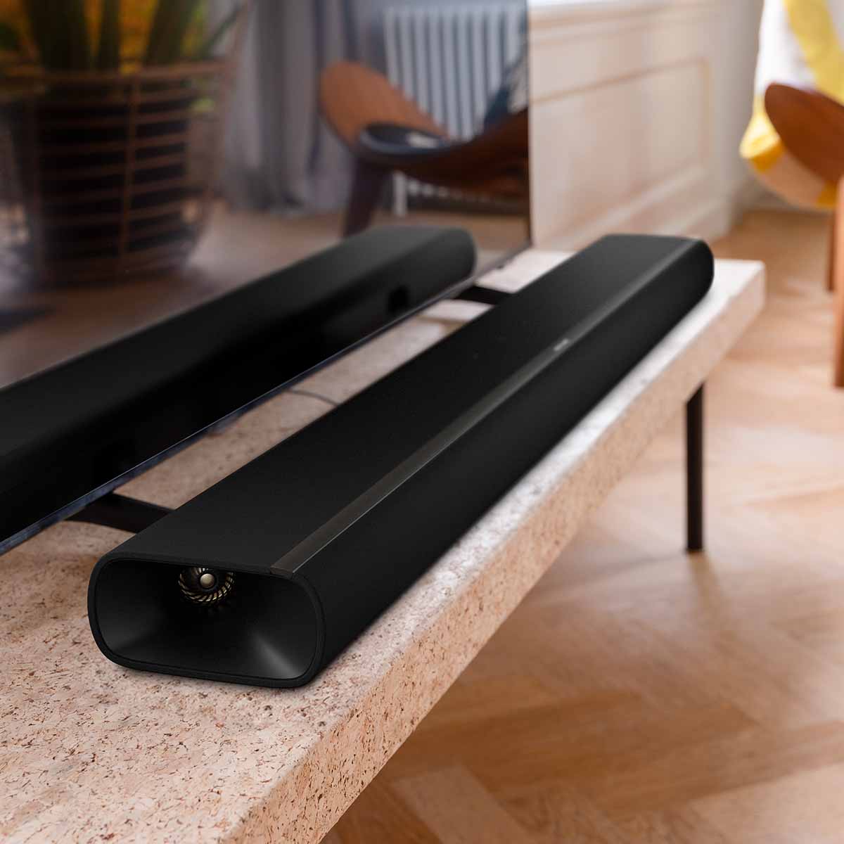 Harman Kardon Enchant 1100 Soudbar closeup lifestyle shot of soundbar on table in front of TV