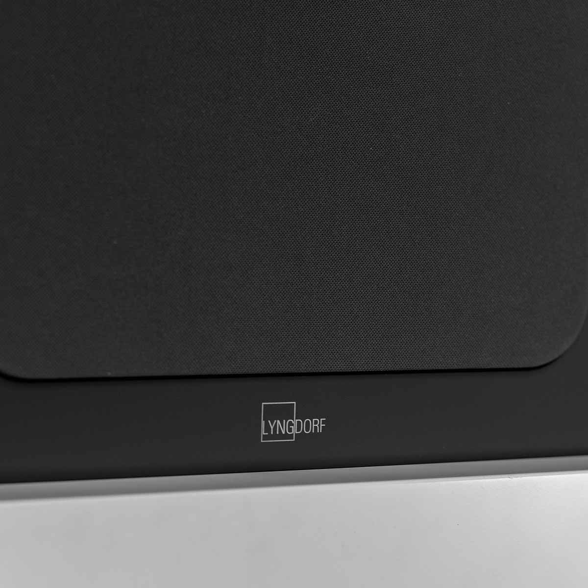Lyngdorf LCR-2 On-Wall LCR Speaker - single black speaker with grille detail of front logo