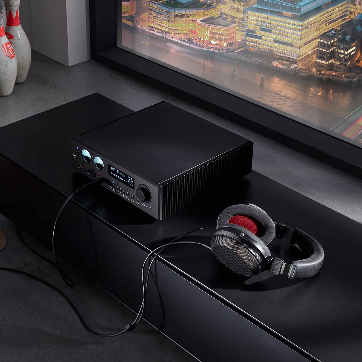 T+A Solitaire P-SE High Performance Open-Back Planar Magnetostatic Headphones - lifestyle shot unit connected to headphone amp on cabinet