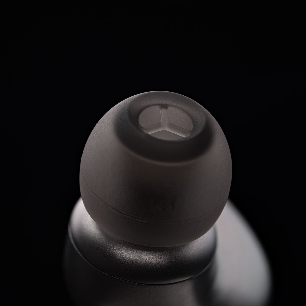Meze Audio ASTRU Single Dynamic Driver In-Ear Monitors - artistic photo of single earbud on black background showing ear tip