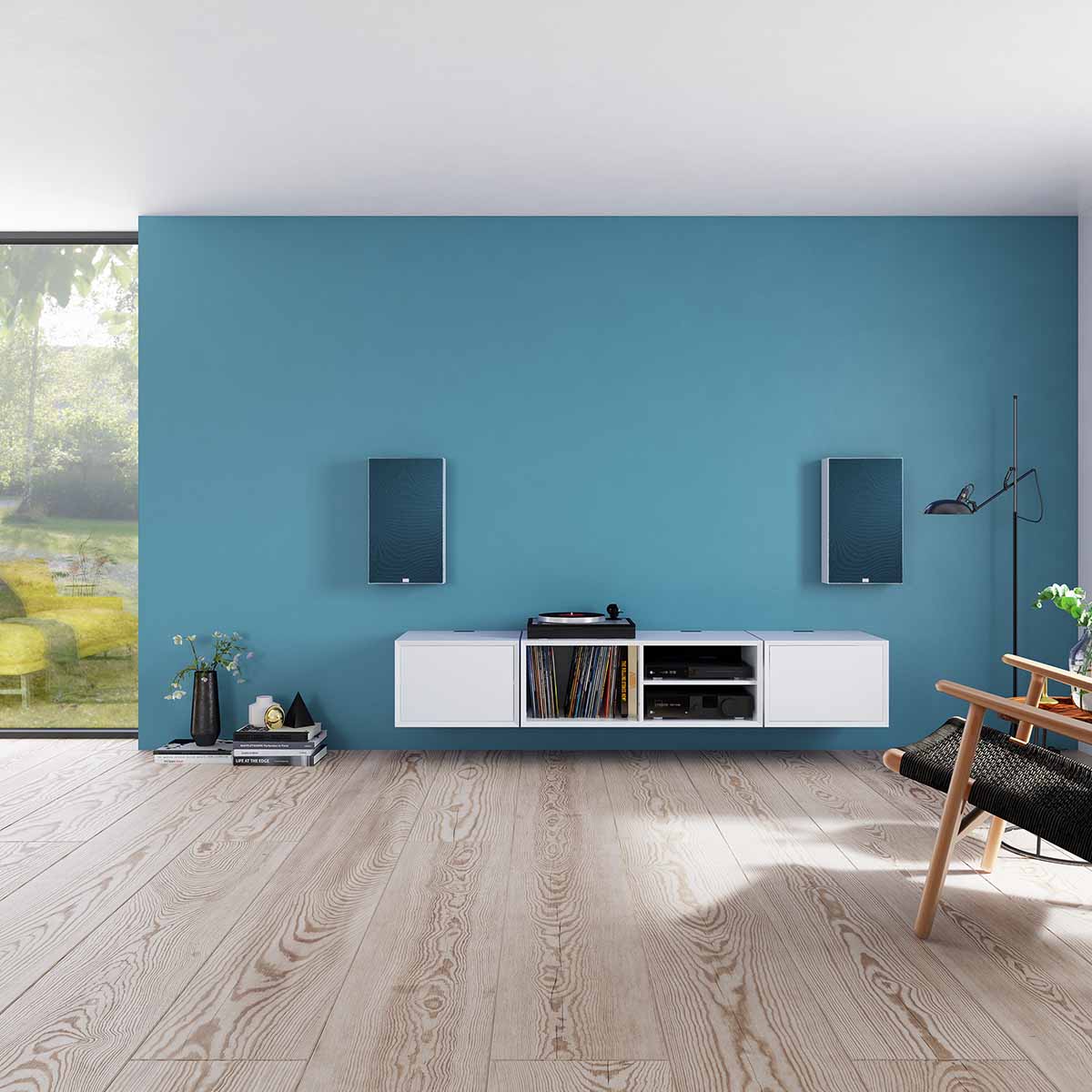 Lyngdorf FR-1 Speaker lifestyle shot front view pair of white units with blue grilles mounted on blue wall above white cabinet