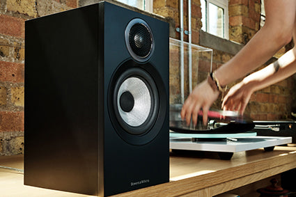 Bowers & Wilkins 607 S3 in black on a counter next to a turntable