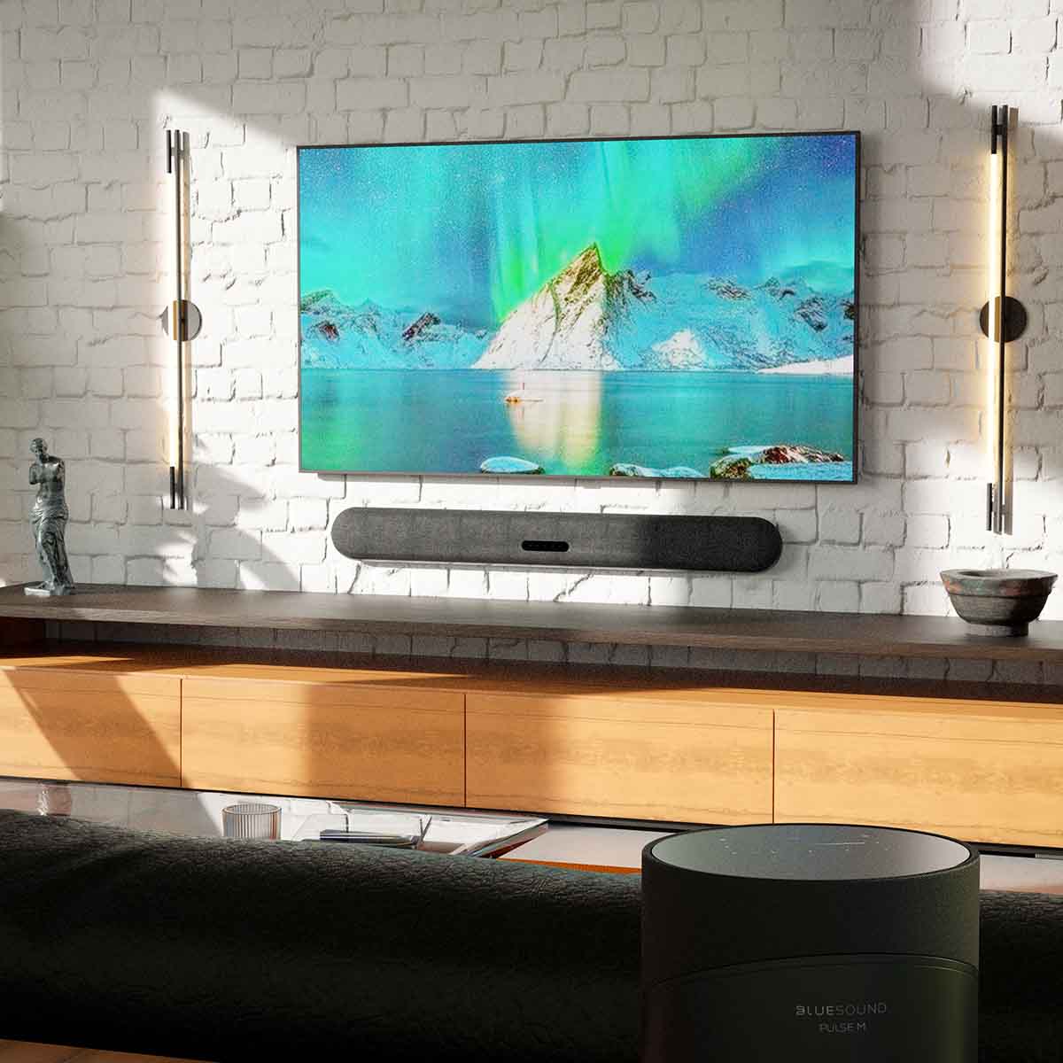 Bluesound Pulse Cinema Multi-Room Streaming Soundbar lifestyle photo of unit wall mounted under TV
