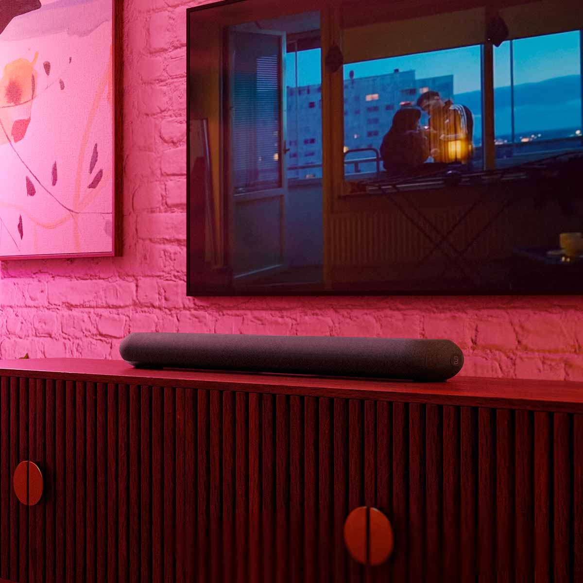 Bluesound Pulse Cinema Mini Multi-Room Streaming Soundbar Black lifestyle photo of unit on cabinet below TV
