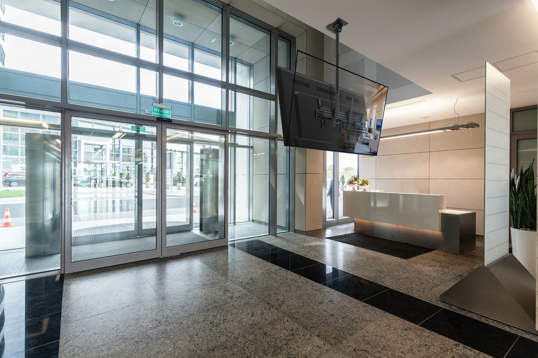 Modern office lobby with glass doors and a reception desk.