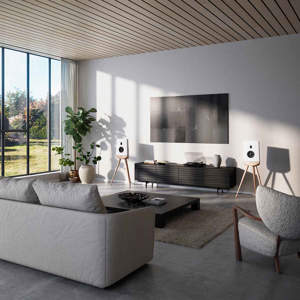 Lyngdorf Cue-100 Speaker lifestyle photo of speakers in living room, pair of white speakers with oak base and no grilles