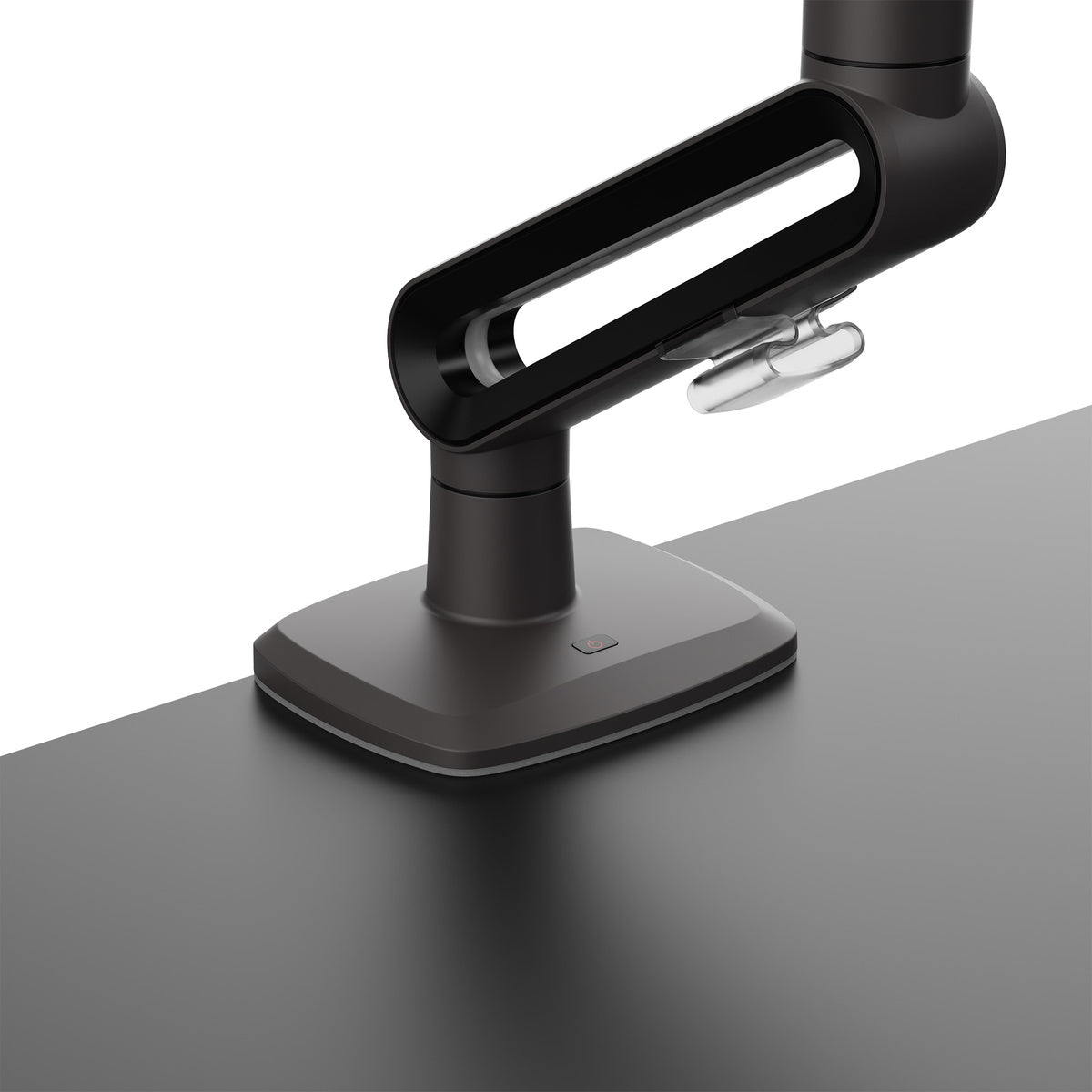 Black adjustable desk lamp on a gray surface with a white background