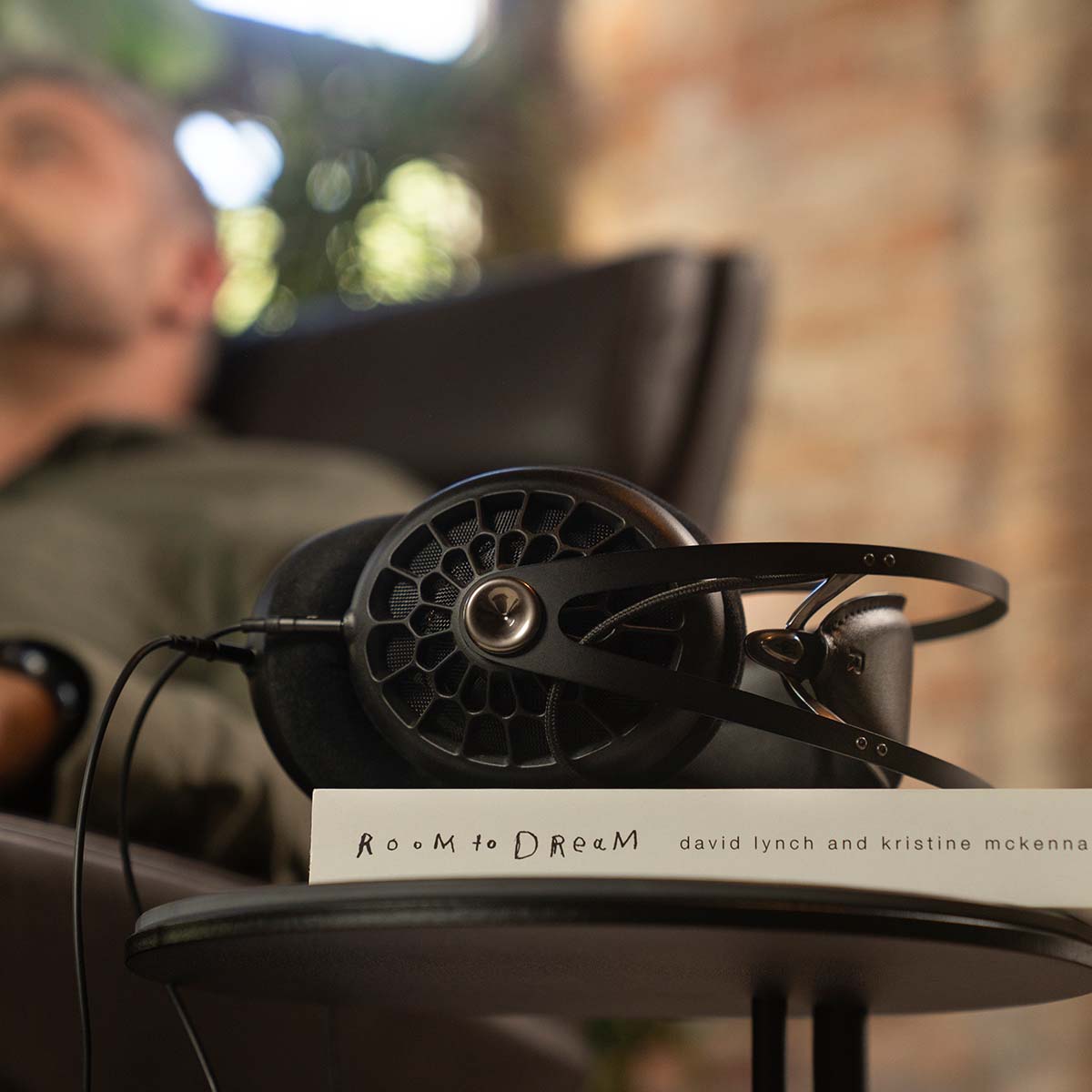 Meze 105 AER Open-Back Headphones - black lifestyle scene laying flat on a book on a table