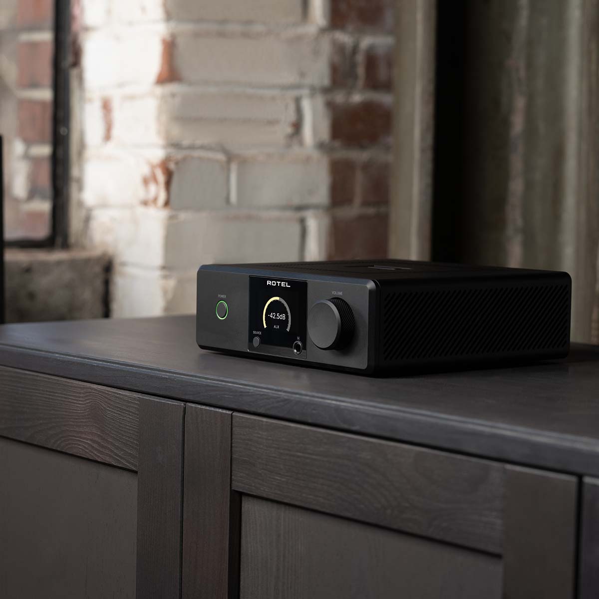 Lifestyle photo Rotel DX-5 Integrated Amplifier - black front view angled left on cabinet