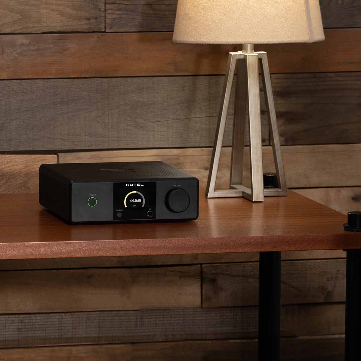 Lifestyle photo Rotel DX-5 Integrated Amplifier - black front view angled right on table to left of lamp