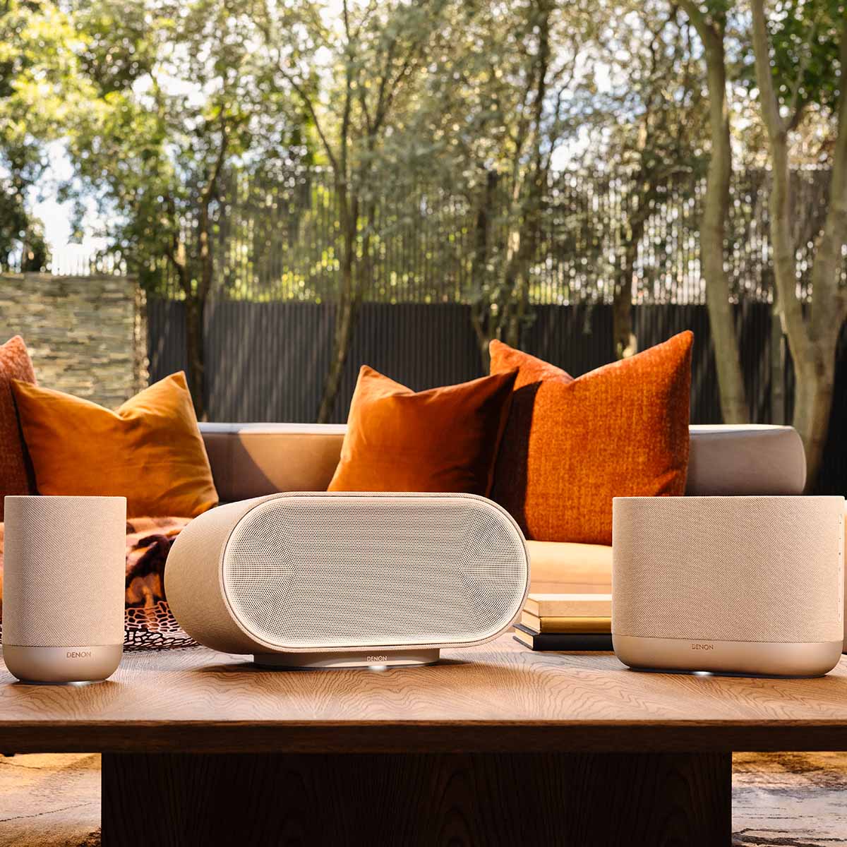 Denon Home Stereo Wireless Smart Speakers - Silver - lifestyle photo front view of each unit in series, from left to right the 200, 600 and 400 with couch and backyard in background