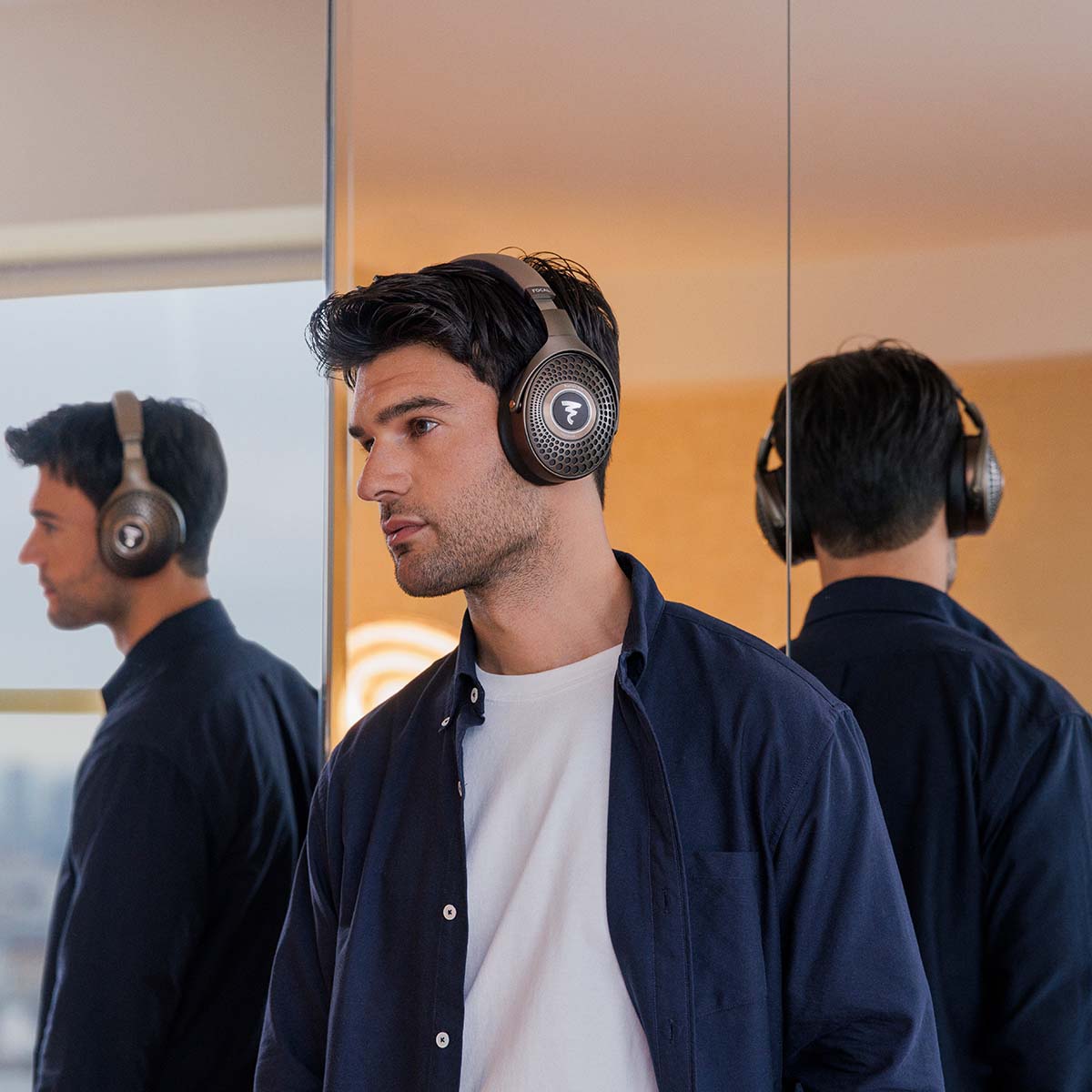 Focal Bathys MG Wireless Over-Ear Active Noise Cancelling Headphones - lifestyle shot man wearing headphones in front of mirror