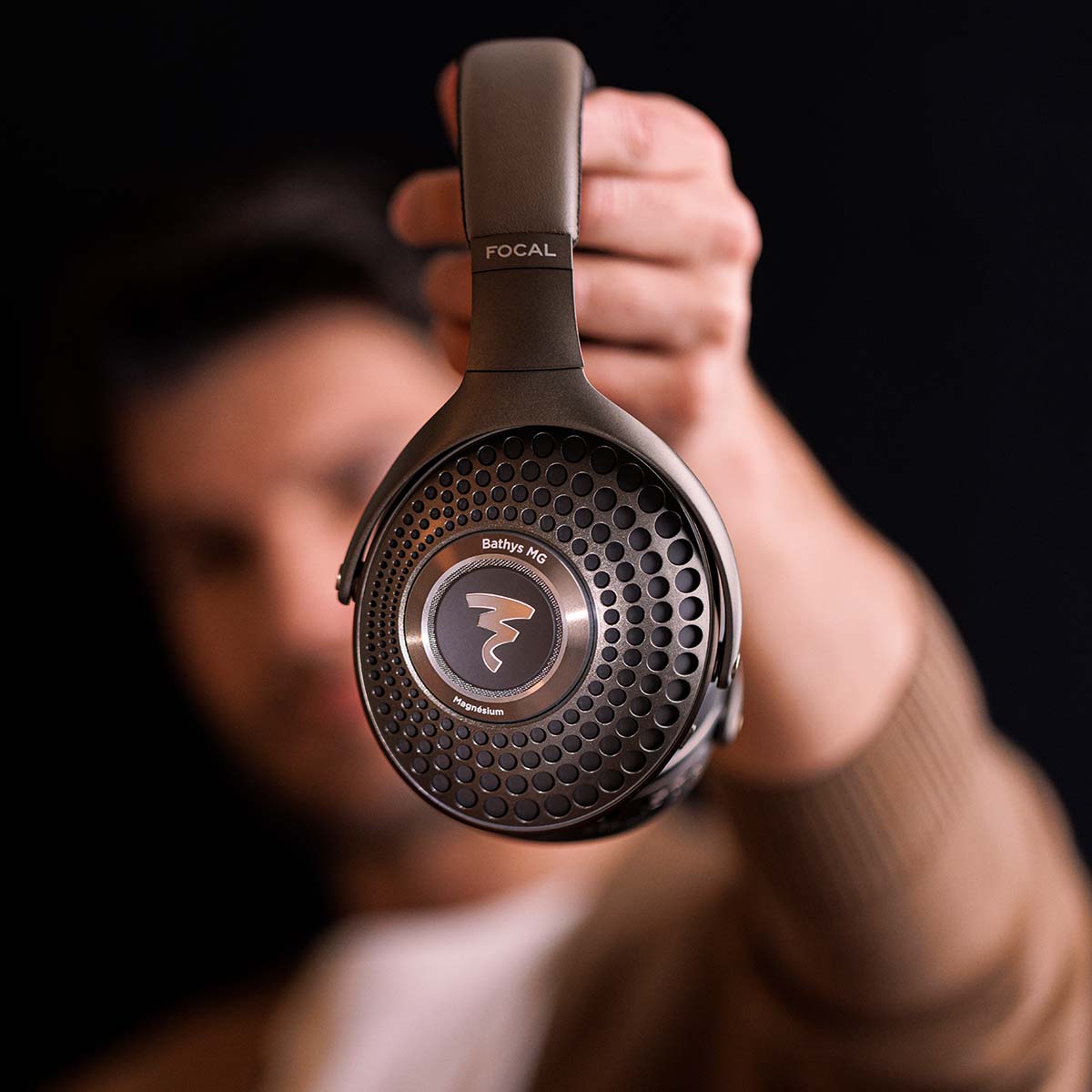 Focal Bathys MG Wireless Over-Ear Active Noise Cancelling Headphones - lifestyle shot man holding headphones