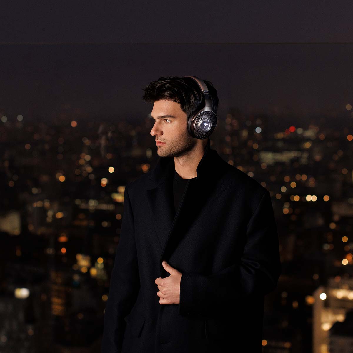 Focal Bathys MG Wireless Over-Ear Active Noise Cancelling Headphones - lifestyle shot man wearing headphones at night