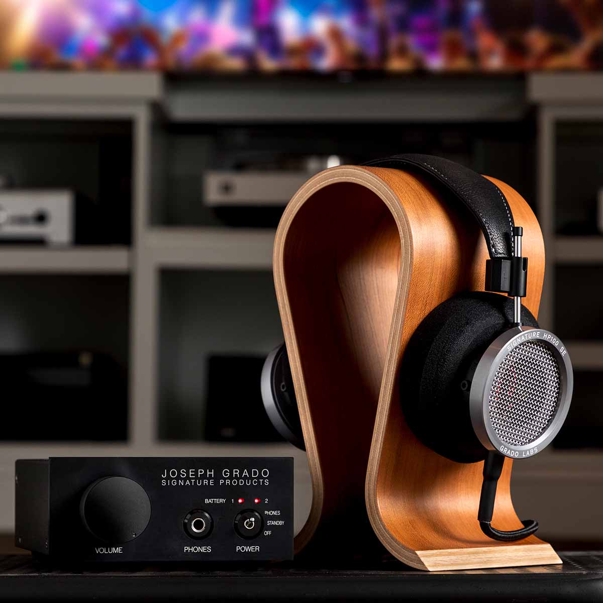 Grado Signature HP100 SE Headphones lifestyle shot three quarter view angled right headphones on wooden stand with separate headphone amp