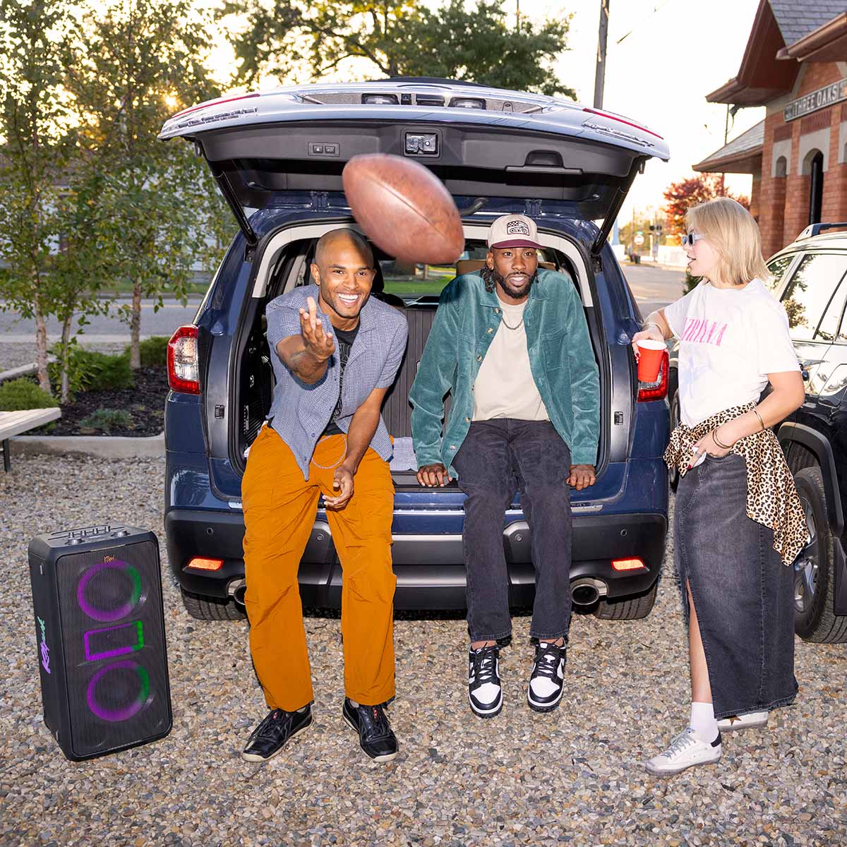 Klipsch Miami Music City Series Premium Party Speaker lifestyle shot with speaker to the left front and side view angled right with purple and green lights