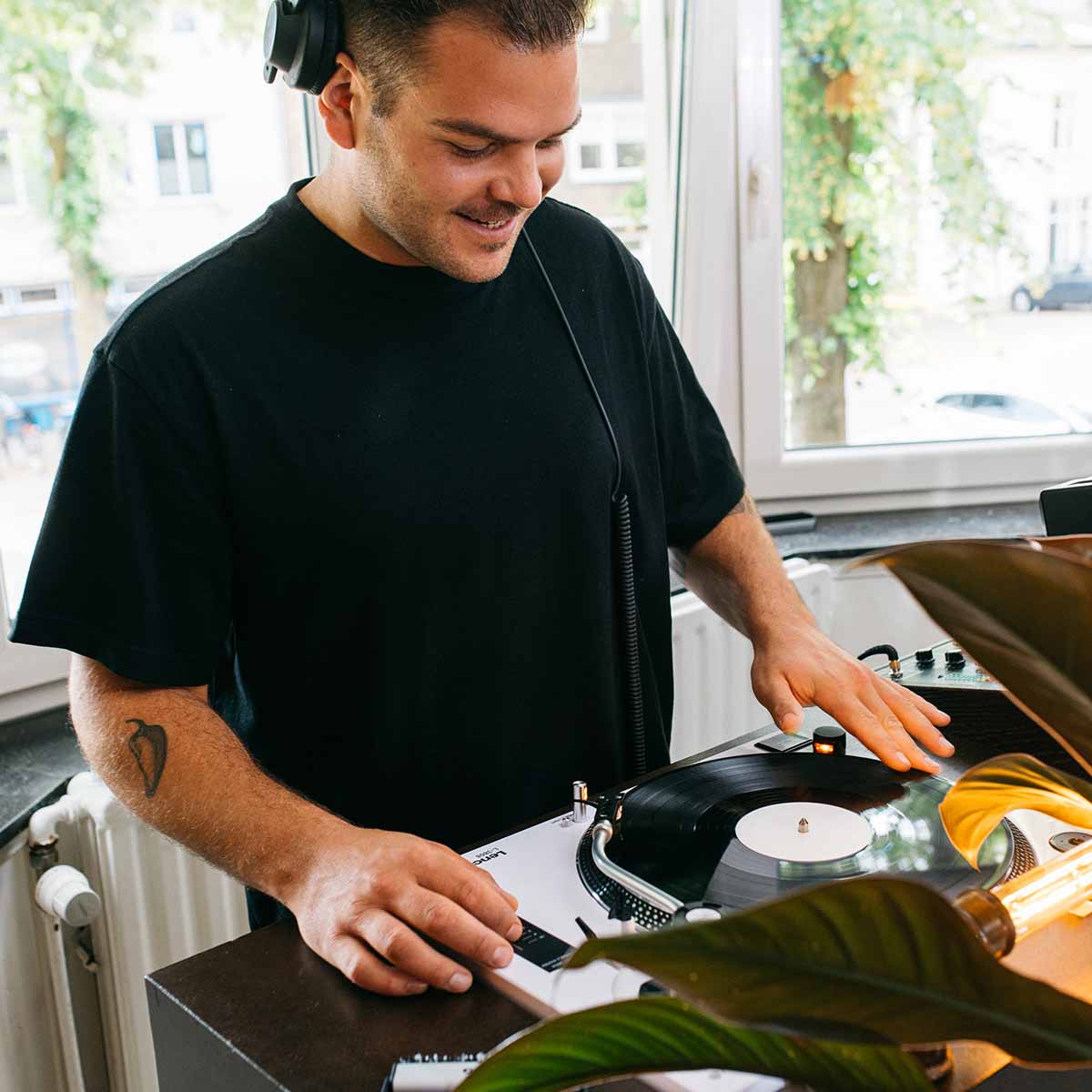 Lenco L-3810 Direct-Drive Turntable w/ Pinch Control - White lifestyle shot of DJ playing a record