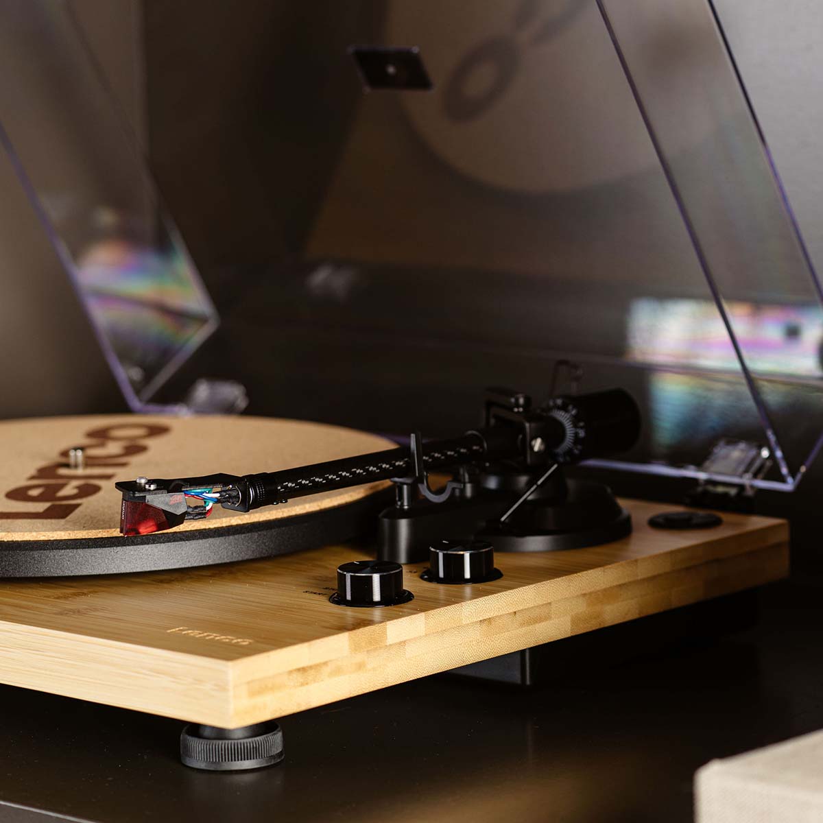 Lenco LBT-335 Bluetooth Turntable w/ Ortofon 2M Red Cartridge lifestyle closeup photo of right side of unit angled left showing tonearm and control knobs with cork mat on platter and open dustcover