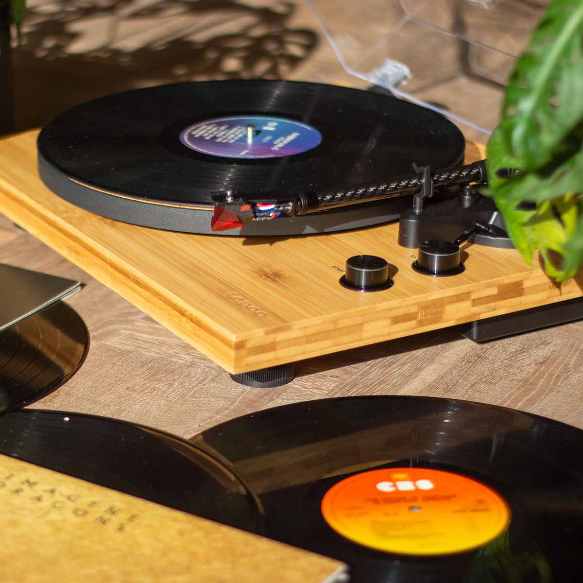 Lenco LBT-335 Bluetooth Turntable w/ Ortofon 2M Red Cartridge lifestyle photo with turntable in background with record on platter