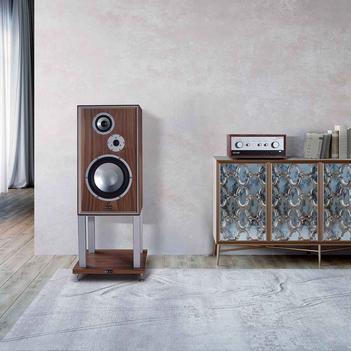 Leak Audio Sandwich 250 Standmount Loudspeakers - Walnut - With Stands - lifestyle shot of single speaker to left of cabinet