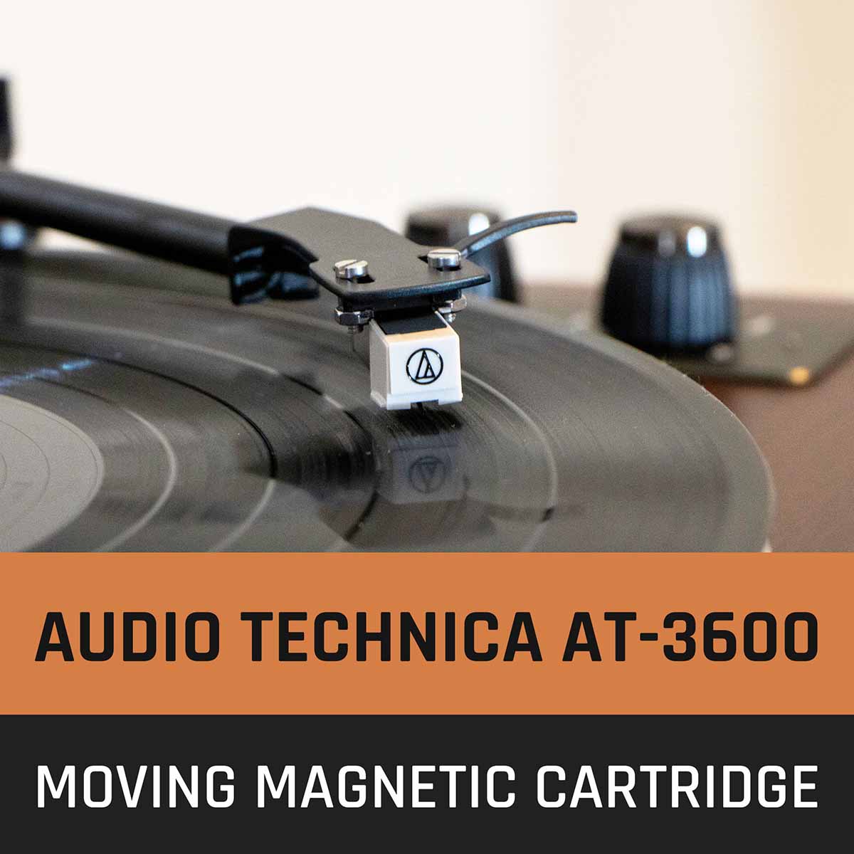 Lenco LS-470 Turntable w/ 80W Speaker System and Bluetooth showing tonearm engaged on record focusing on cartridge, text to bottom of image reading Audio Technica AT-3600 Moving Magnetic Cartridge