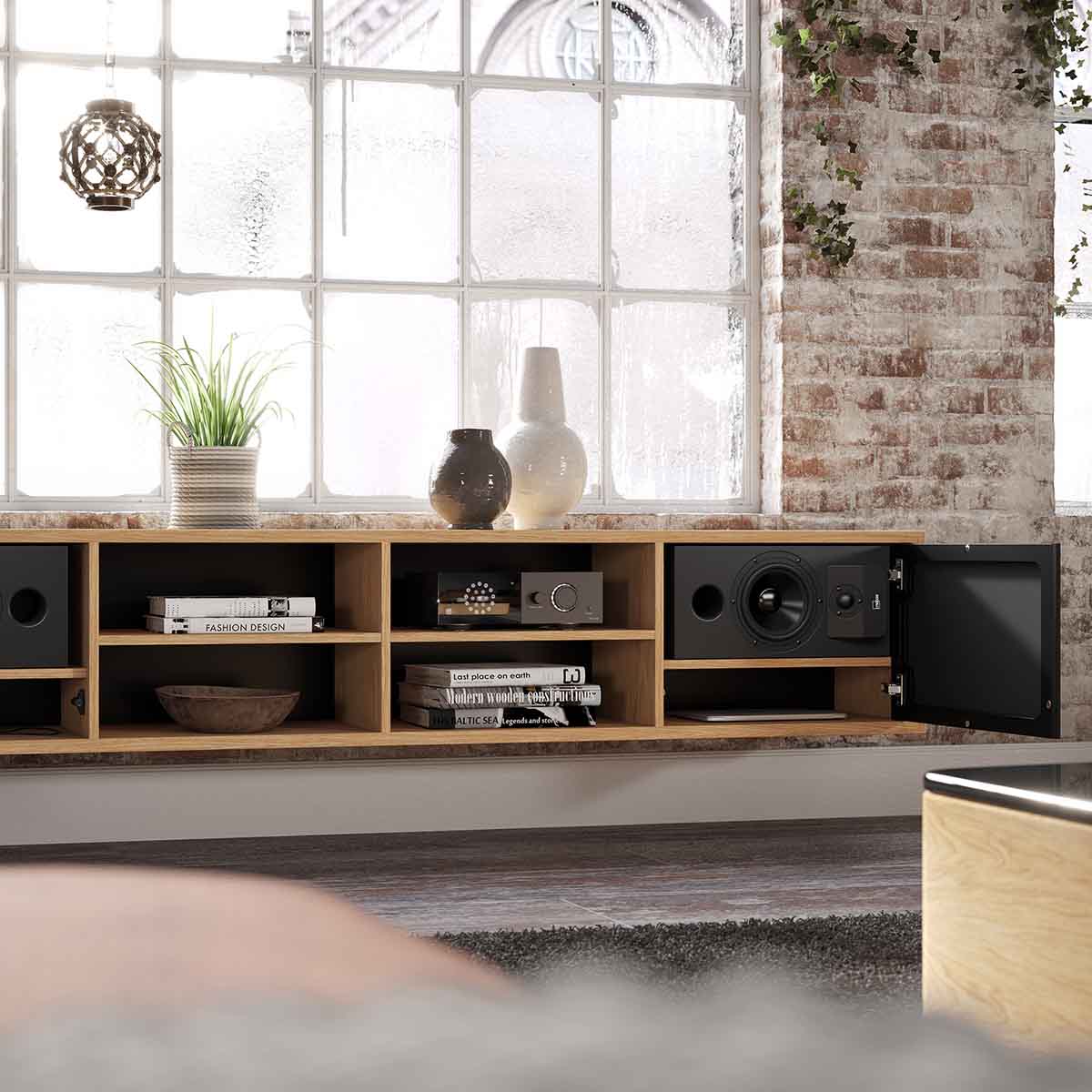 Lyngdorf CS-1 Speaker lifestyle shot of speaker in cabinet with door grille open