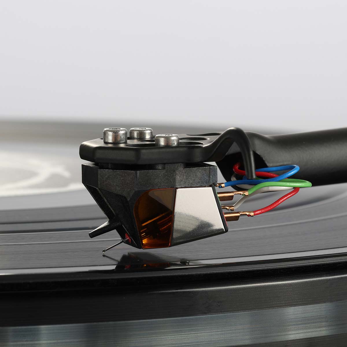 Rega ND9 Moving Magnet Phono Cartridge - side view of cartridge mounted on tone arm with needle on record
