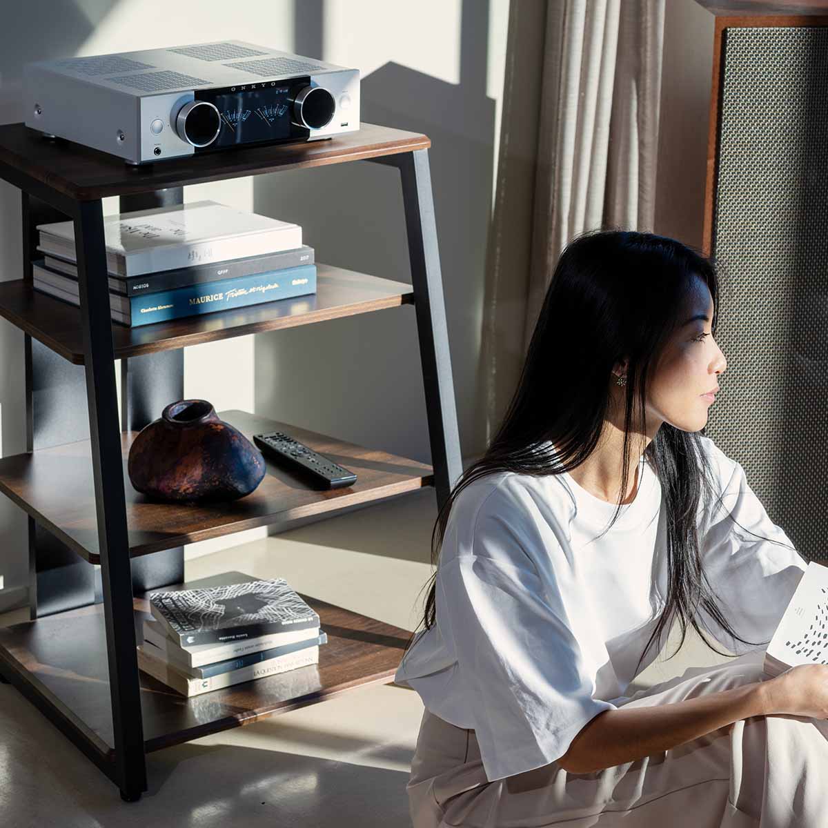 Onkyo Muse Y-50 Network Integrated Amplifier - Silver - lifestyle view of unit on shelf to left with seated woman to right