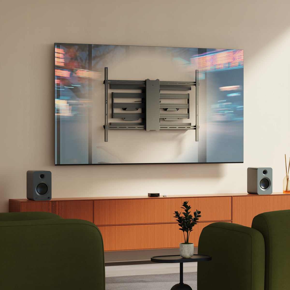 Modern living room with a large TV mounted on the wall, speakers, and green chairs.