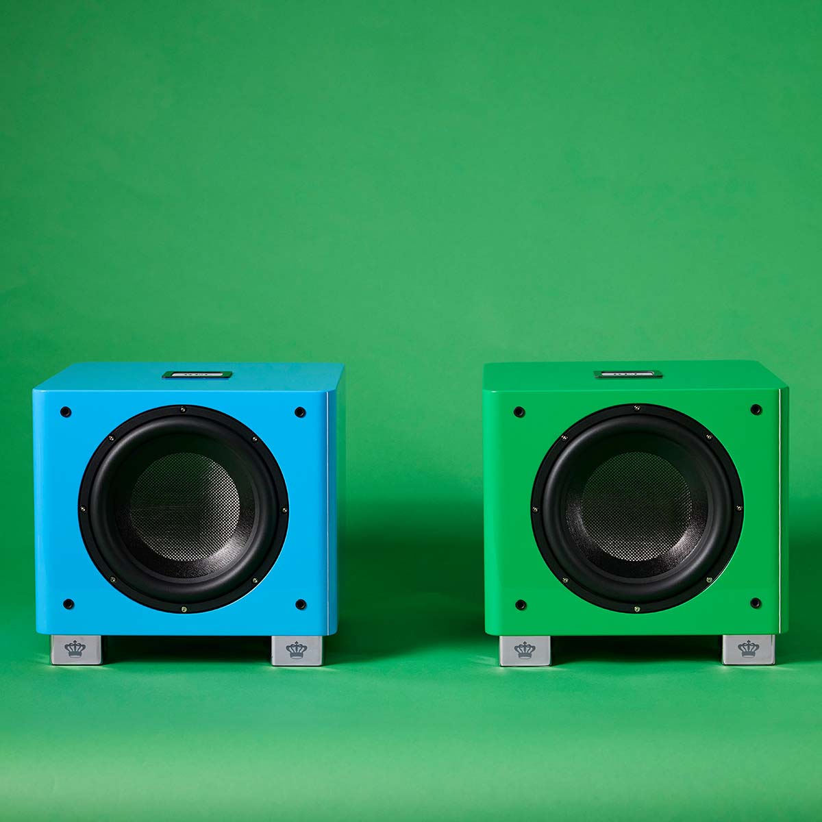 REL Acoustics T/9x SE Subwoofer Blue unit to left and Green unit to right front view without grilles on green background