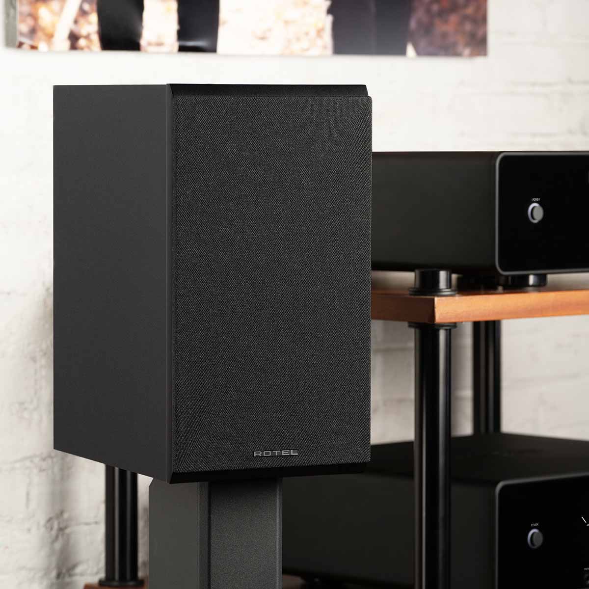 Rotel Amora 5 Passive Bookshelf Loudspeakers - Black - Lifestyle photo front and side view angled right with grille