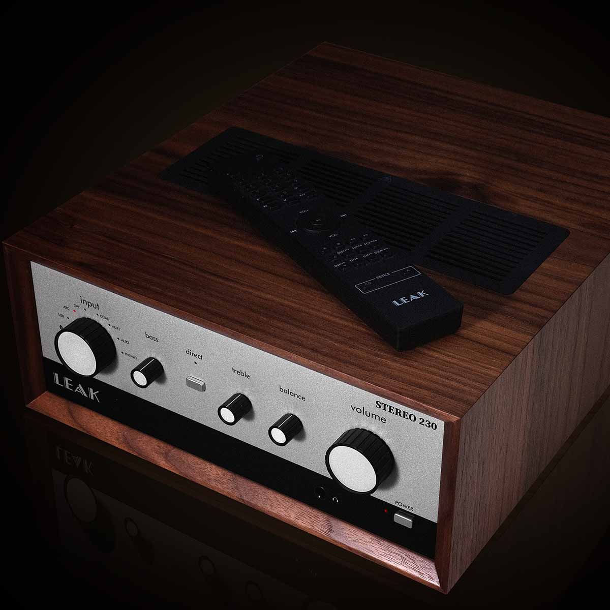 Leak Audio Stereo 230 Integrated Amplifier - Walnut - top and front view angled left dark background remote on unit