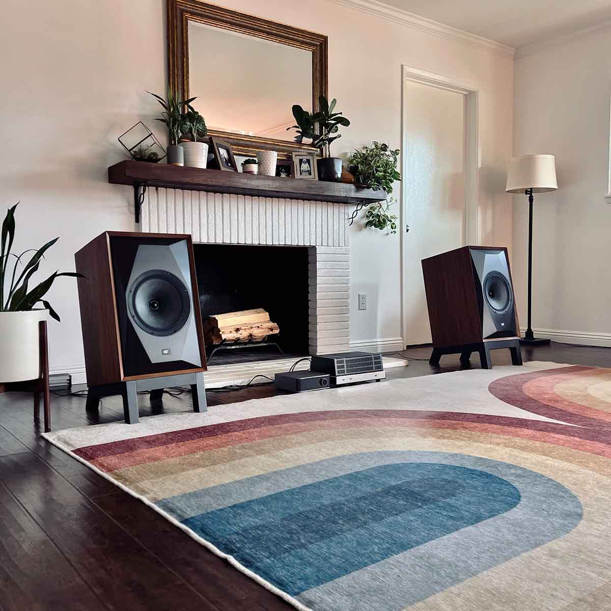 MoFi Electronics SourcePoint 10 Master Edition Bookshelf Speakers - walnut - lifestyle photo pair of speakers on stands around fireplace