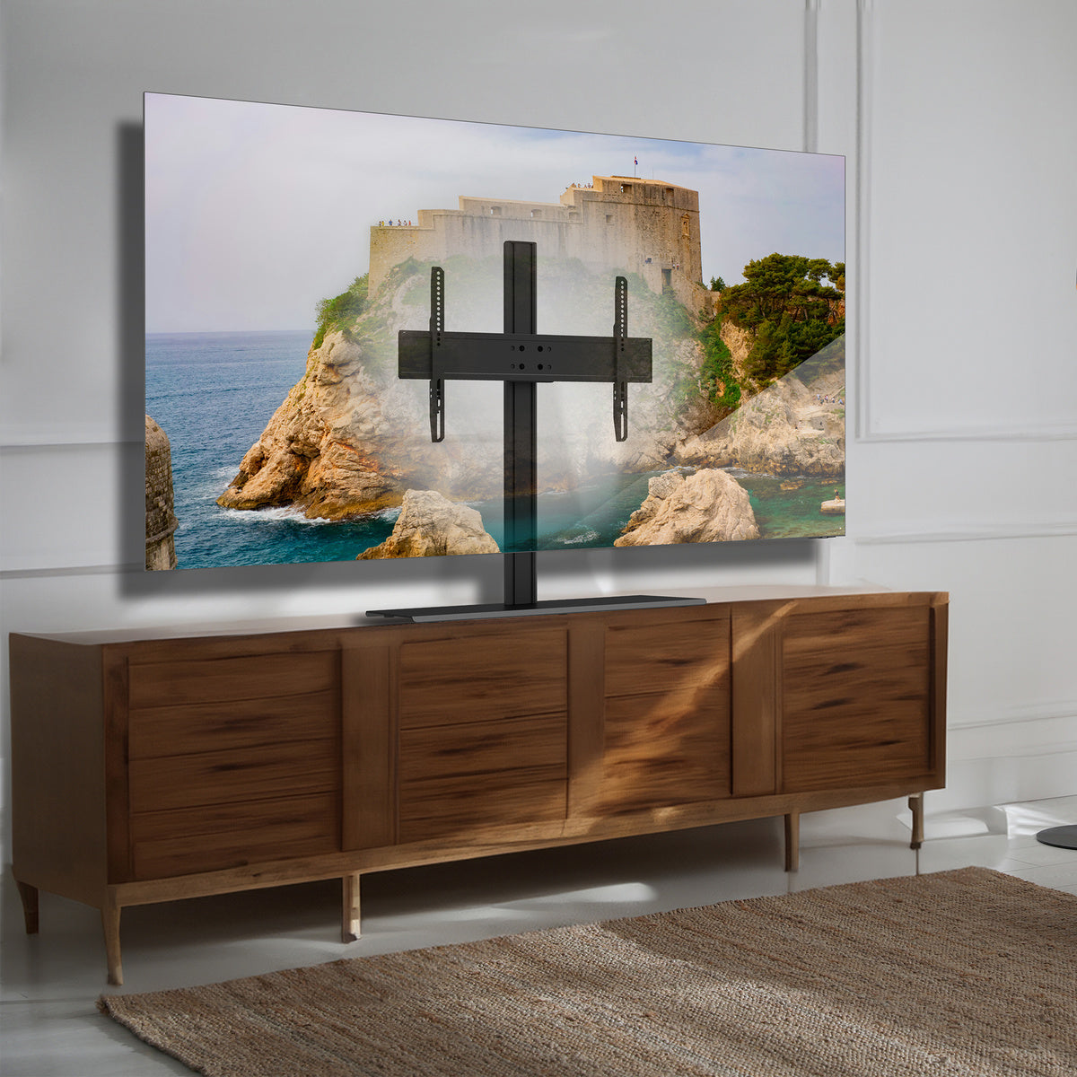 Wooden entertainment console with a TV displaying a scenic wall mount.