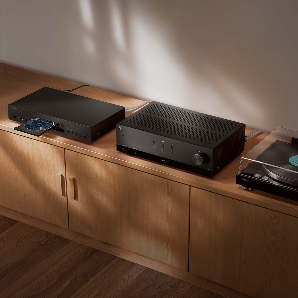 Yamaha R200A 2-Channel Hi-Fi Stereo Receiver with Bluetooth - Black - lifestyle photo of unit on cabinet between record player and disc player