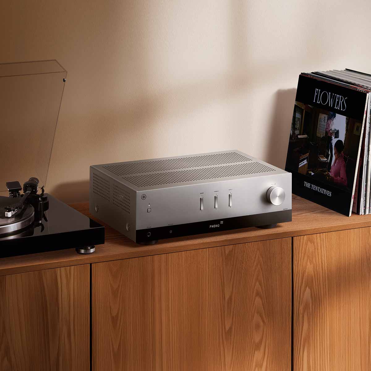Yamaha R200A 2-Channel Hi-Fi Stereo Receiver with Bluetooth - Silver - lifestyle photo of unit on cabinet between record player and records