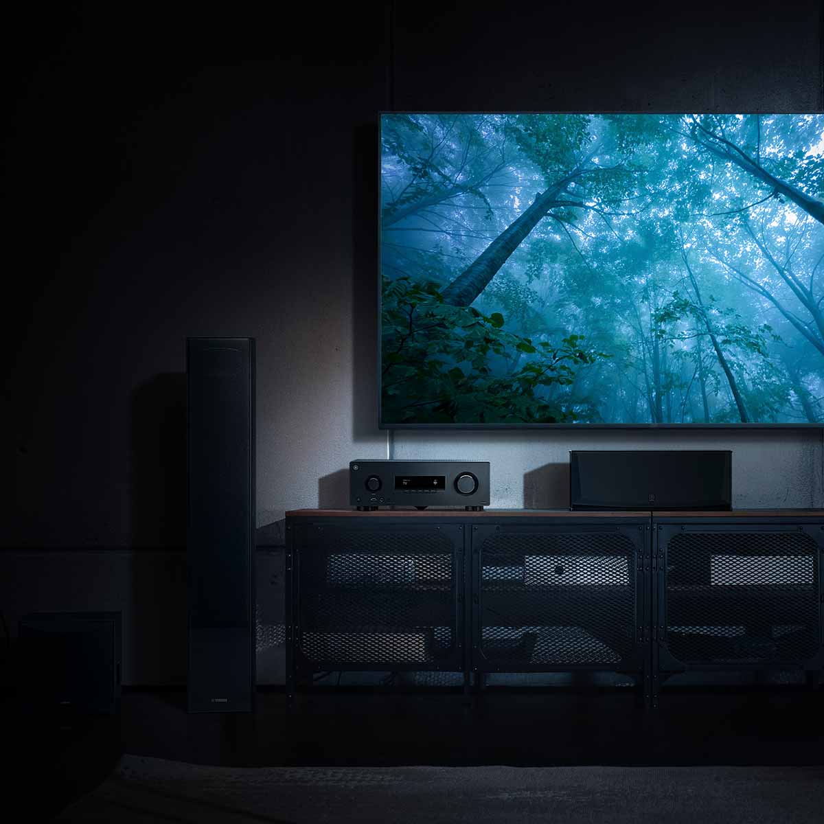 Yamaha RX300A 5.2-Channel AV Receiver - lifestyle image with dark lighting of unit on cabinet front view below TV