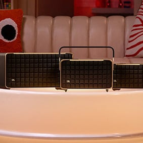 JBL Authentics Speakers on a round table in front of a couch