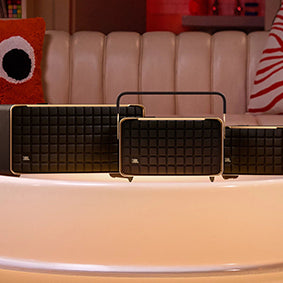 JBL Authentics Speakers on a round table in front of a couch