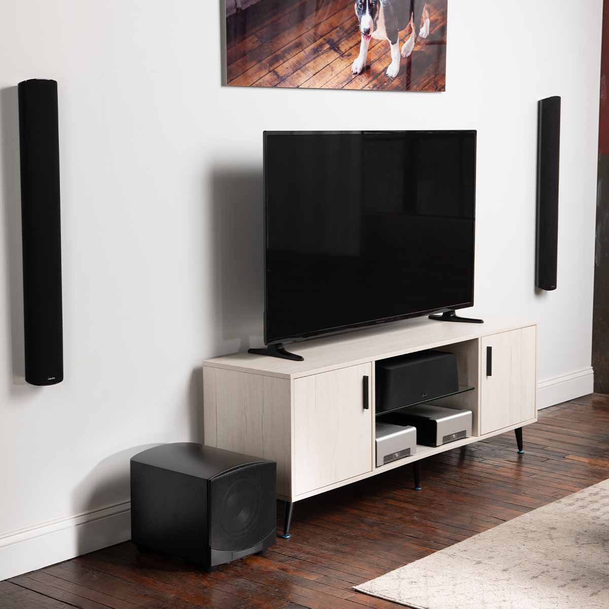 GoldenEar ForceField 40 - 10” Compact Subwoofer - Black - sitting on floor next to entertainment console