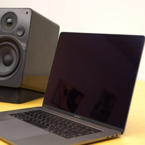 Peachtree M24 Powered Speakers in black set up with a Macbook Pro