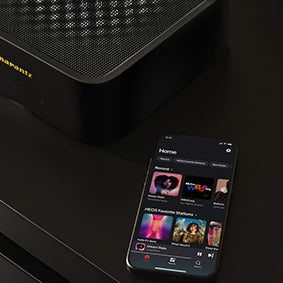 Marantz Model M1 Wireless Streaming Amplifier next to a smartphone with the Heos app open