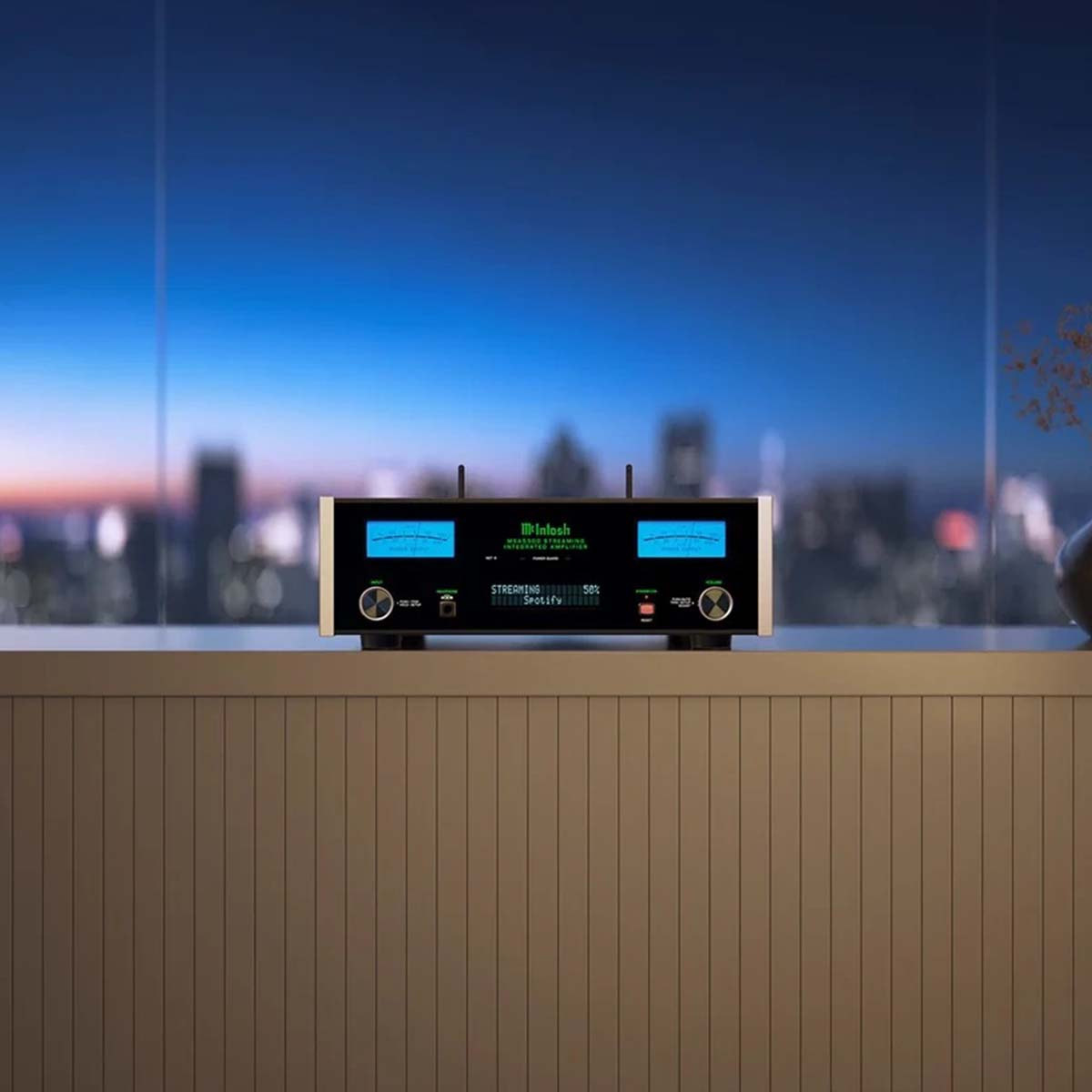 McIntosh MSA5500 Streaming Integrated Amplifier - black lifestyle front view shot on counter with cityscape at dusk in background
