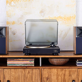 JBL Spinner Turntable on a console table between a set of speakers