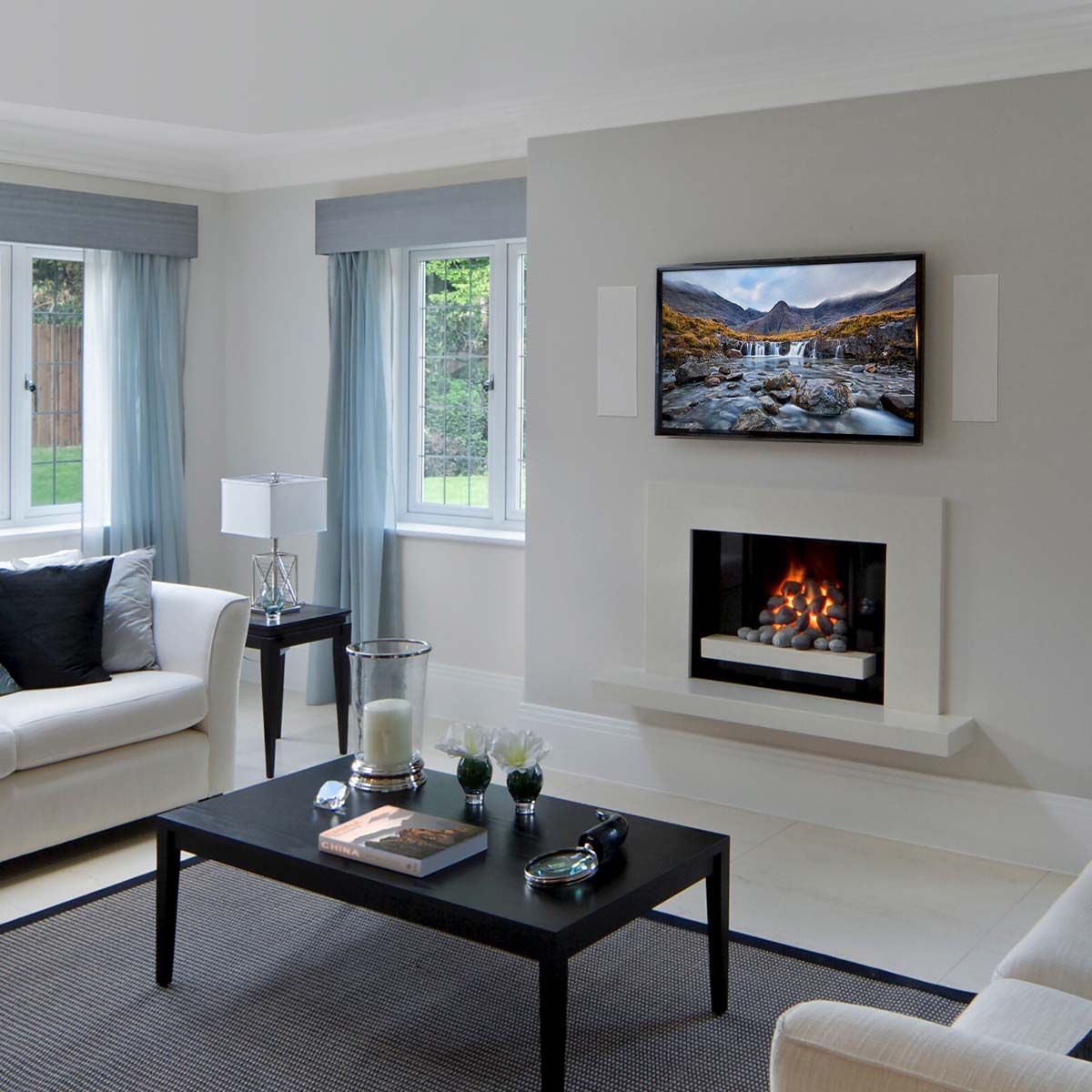 MartinLogan Tribute 5XW In-Wall Speakers installed on each side of a tv above fireplace