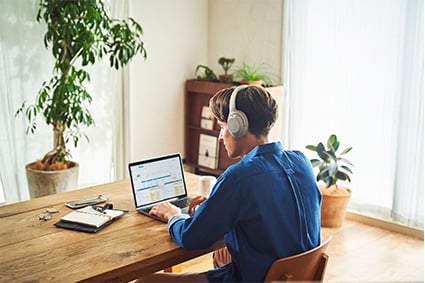 male model wearing noise cancelling headphones while working from home
