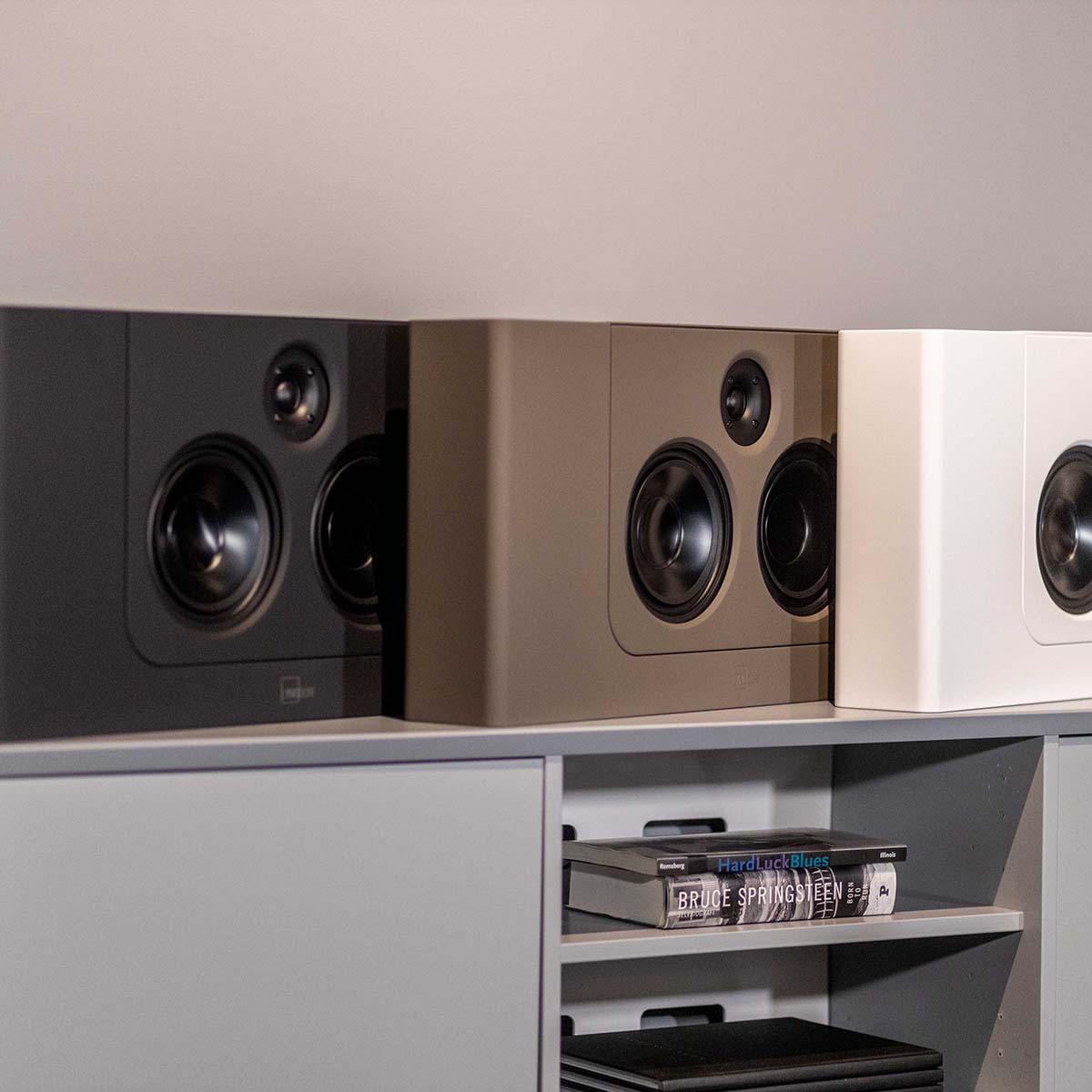 Lyngdorf LCR-2 On-Wall LCR Speaker - three speakers, L-R black brown white, all on cabinet